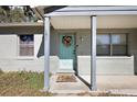 Inviting front entrance featuring a light blue door, wreath, colorful welcome mat and brick facade at 151 Shiloh Ave, Lady Lake, FL 32159