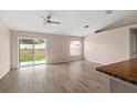 Bright living room featuring sliding glass doors leading to the backyard and wood flooring at 15318 Margaux Dr, Clermont, FL 34714