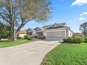 Beautiful single-story home featuring a well-maintained lawn, mature landscaping, and a two-car garage at 17635 Se 82Nd Annadale Ter, The Villages, FL 32162