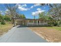 Charming single-story home with a carport and inviting front porch, surrounded by a well-maintained yard at 211 Sara Ln, Leesburg, FL 34748