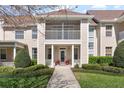 Beautiful townhome exterior showcasing a covered porch, second-story balcony, manicured lawn, and attractive landscaping at 220 Nautica Mile Dr, Clermont, FL 34711