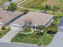 Aerial view of a single-Gathering home with lush landscaping, a golf course view, and mature trees at 26694 Otter Creek Ln, Leesburg, FL 34748