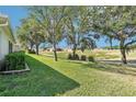 Mature trees offer shade in back yard, near golf course and marshland, creating a picturesque and private oasis at 26821 Augusta Springs Cir, Leesburg, FL 34748