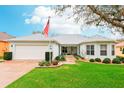 Charming single-story home featuring a well-manicured lawn, two-car garage, and an inviting entrance at 26821 Augusta Springs Cir, Leesburg, FL 34748