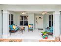 Inviting front porch with comfortable seating, ceiling fans, and a welcoming entrance at 26821 Augusta Springs Cir, Leesburg, FL 34748