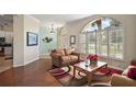 Cozy living room featuring hardwood floors, large windows with plantation shutters, and elegant decor at 288 Bent Oak Ct, Leesburg, FL 34748