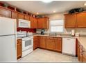 A cozy kitchen with wooden cabinets, white appliances, and ample counter space at 3076 Gulfport Ct, The Villages, FL 32163