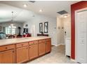 Kitchen island with wood cabinets opens to a combined dining and living space at 3076 Gulfport Ct, The Villages, FL 32163