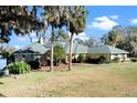 Inviting one-story brick home with a well-maintained lawn, mature palm trees, and a charming walkway at 37734 N County Road 44A, Eustis, FL 32736