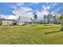 Exterior view of the home with a metal roof, a large yard and a shed at 42141 Chinaberry St, Eustis, FL 32736