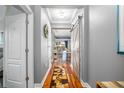 Hallway with a wooden sliding barn door, wood floors, and neutral paint, leading to the living area at 5262 Royce Dr, Mount Dora, FL 32757