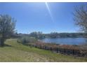 Beautiful water view featuring a fence and mature trees on a sunny day at 569 Bellflower Way, Clermont, FL 34715