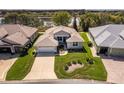 An aerial view of a well maintained home with a manicured lawn and view of the lake at 5824 Blue Savannah Dr, Leesburg, FL 34748