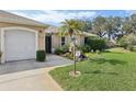 Charming home with a well-kept lawn, lovely landscaping, and a welcoming walkway to the front door at 610 Espana St, The Villages, FL 32159