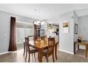 Cozy dining area with wood table, chandelier, and sliding door access to the outdoors at 620 Dominguez Dr, The Villages, FL 32159