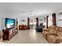 Spacious living room featuring wood floors, a ceiling fan, and sliding glass doors at 620 Dominguez Dr, The Villages, FL 32159