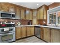 Well-lit kitchen features stainless steel appliances, tiled backsplash, and wood cabinets at 630 E 8Th Ave, Mount Dora, FL 32757