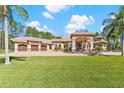 Estate home with a circular brick driveway, three-car garage, lush lawn, and covered portico at 6801 Silver Charm Ct, Leesburg, FL 34748