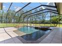 Screened in pool with a waterfall feature, spa, and ample space for entertaining at 6801 Silver Charm Ct, Leesburg, FL 34748