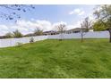 Well-maintained backyard featuring a white fence and lush green grass at 7040 Oxbow Rd, Minneola, FL 34715