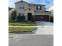 Charming two-story home with a well-manicured lawn and two-car garage at 7040 Oxbow Rd, Minneola, FL 34715