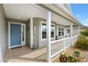 Inviting covered porch with beautiful blue door and welcome sign to greet guests at 879 Pisano Way, The Villages, FL 32163