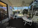 Relaxing screened porch with ceiling fan, table, and ample seating at 1004 Matthew Ave, Lady Lake, FL 32159