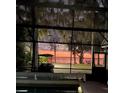 Screened-in patio offers beautiful sunset views of the water and outdoor seating area at 11215 Dead River Rd, Tavares, FL 32778