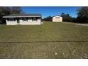Exterior view of home and detached garage on a sprawling green lawn at 11701 Layton St, Leesburg, FL 34788