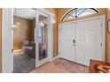 Inviting entryway featuring double doors, tile flooring, and an adjacent room with a comfortable seating area at 12127 Cypress Landing Ave, Clermont, FL 34711