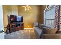 Cozy living room with a comfortable sofa, TV, and large window, creating a relaxing atmosphere at 12127 Cypress Landing Ave, Clermont, FL 34711