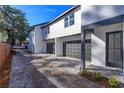 Contemporary home featuring a paved driveway leading to gray garage doors and a modern front door at 1307 E Harding St, Orlando, FL 32806