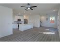 Bright and airy living room featuring an open kitchen concept with modern appliances, fixtures, and wood floors at 1307 E Harding St, Orlando, FL 32806