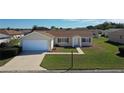 Well maintained single-story home featuring an attached garage and manicured lawn at 13828 Se 85Th Cir, Summerfield, FL 34491