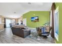 Open-concept living room featuring wood floors, green accent walls, and ample natural light at 1391 Willow Crest Dr, Clermont, FL 34711