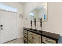 Bright entryway featuring tile flooring, a decorative console table, mirror and a white front door at 1524 Flange Dr, Davenport, FL 33896