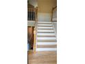 View of the staircase with white risers and wood treads connecting the home's levels at 16017 Harbor Oaks Dr, Montverde, FL 34756