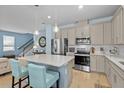 Spacious kitchen featuring stainless steel appliances, shaker cabinets, and a white countertop island at 17291 Saw Palmetto Ave, Clermont, FL 34714