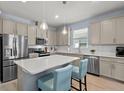 Bright kitchen features stainless steel appliances, shaker cabinets, and a white countertop island at 17291 Saw Palmetto Ave, Clermont, FL 34714