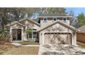 Charming two-story home featuring a well-manicured lawn and a two-car garage at 17421 Woodfair Dr, Clermont, FL 34711