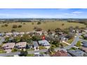 Expansive aerial view of a residential community surrounded by green pastures at 20740 Queen Alexandra Dr, Leesburg, FL 34748