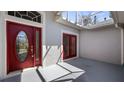Inviting front entrance featuring a beautiful red door and glass sidelights at 20740 Queen Alexandra Dr, Leesburg, FL 34748