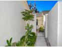 Charming courtyard entrance with lush landscaping, iron gate and whitewashed walls at 2225 Cypress Ct # 2C, Tavares, FL 32778