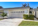 Attached two-car garage with carriage door, front lawn and walkway at 2225 Cypress Ct # 2C, Tavares, FL 32778