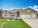 Charming home featuring a well-manicured lawn, tasteful landscaping, and a three-car garage at 24002 Robinwood St, Leesburg, FL 34748