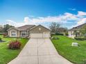 Charming home featuring a well-manicured lawn, tasteful landscaping, and a three-car garage at 24002 Robinwood St, Leesburg, FL 34748