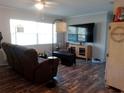 Comfortable living room with hardwood floors, a ceiling fan, and a large flat screen television at 2416 Briarwood Ln, Eustis, FL 32726