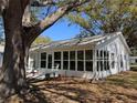 Back of home featuring a spacious enclosed sunroom with lots of windows and patio at 25527 Oak Aly, Leesburg, FL 34748