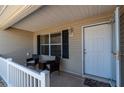 Cozy front porch area with seating, offering a welcoming entry to the home with an open door and stylish exterior lighting at 314 Olanta Dr, The Villages, FL 32162