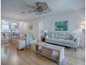 Bright living room with a ceiling fan and hardwood floors that connect to the dining area at 3337 Ashbrook Pl, The Villages, FL 32162